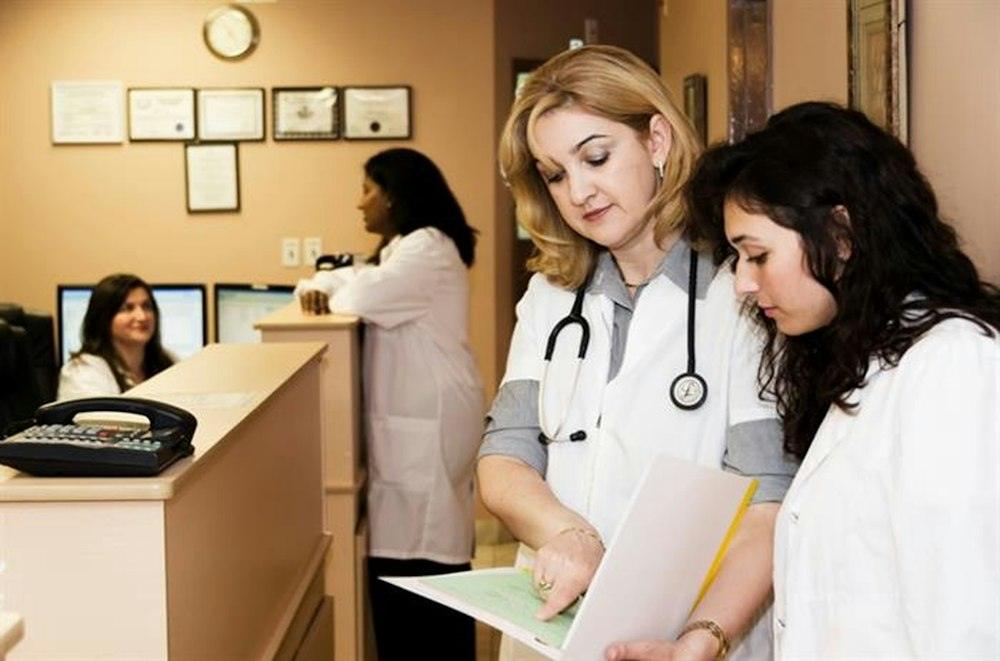 Equipe de clínica conferindo documentos na recepção